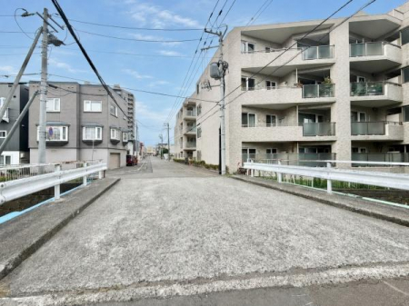 ���̑����n�@�O�ʓ��H��ʕ�������B�e�����l�q�ł��B�{�����̂��΂�삪����A��ɂ͎��ӓ��H�ւȂ��鋴���˂����Ă��܂��B�ˌ��ĂƏW���Z��������ԕ��R�ȏZ��X�ŁA���͂̓��H�󋵂╵�͋C�����n�ł��m�F���������܂��B